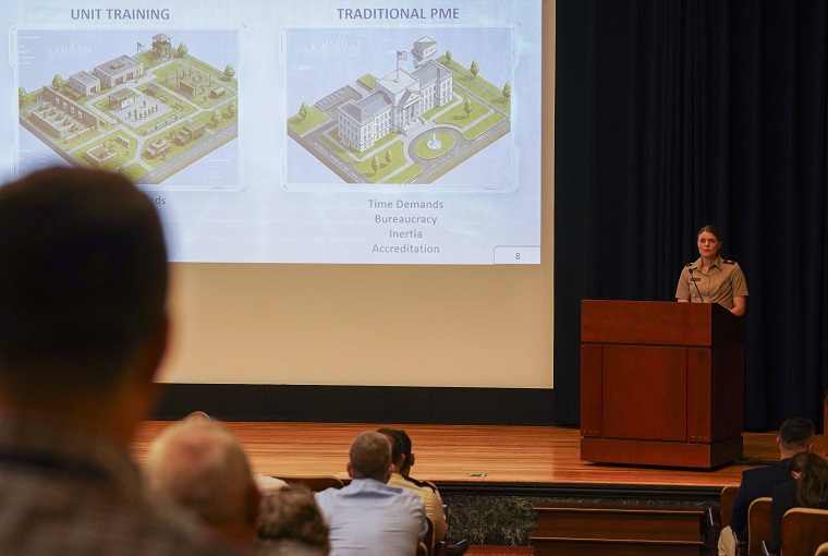 A woman speaking at a podium in an auditorium.