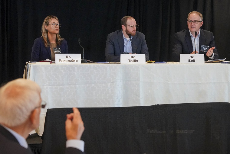 Several people at a conference, with a man talking