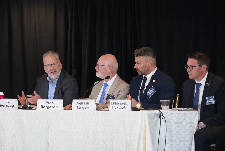 Several people at a symposium confernce table