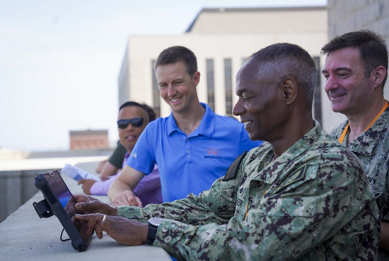 U.S. Naval War College (NWC) President Rear Adm. Darryl Walker, center, pilots a Lightfish unmanned surface vehicle (USV) during a demonstration conducted by Seasats, a U.S.-based developer of autonomous maritime systems, at NWC onboard Naval Station Newport, Rhode Island, July 25, 2025.