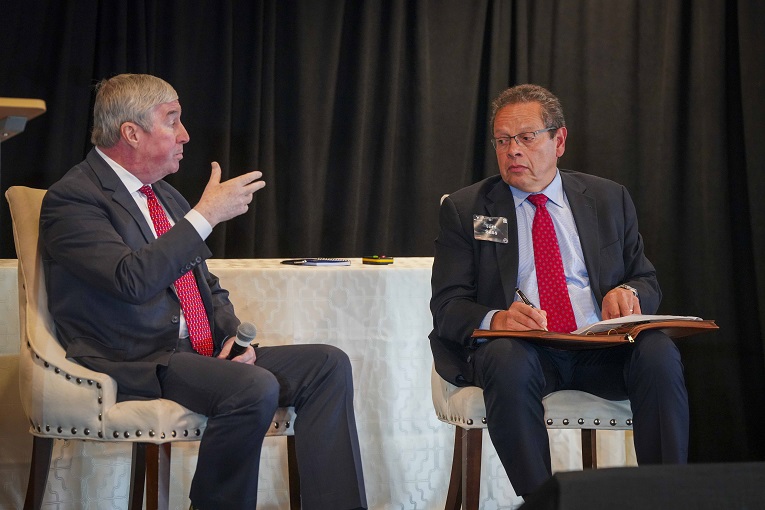 Two men speaking at a conference