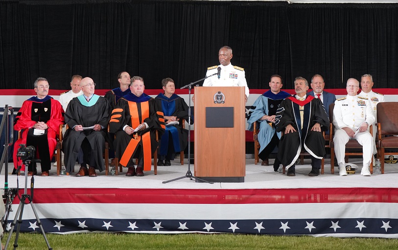 The graduation stage, with many faculty and college leadership on it.