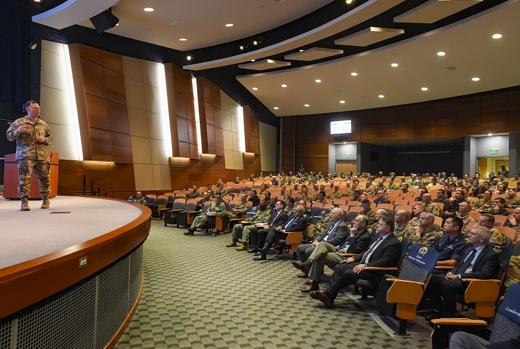 A man speaking to an auditorium full of people