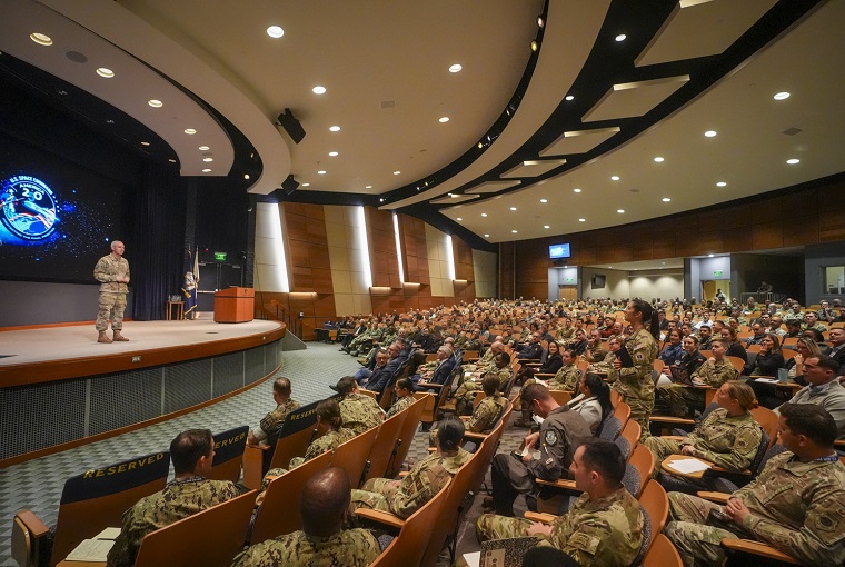 A man speaking to an auditorium of people