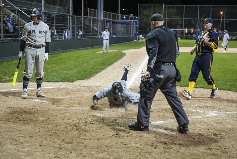 A baseball player sliding into home plate