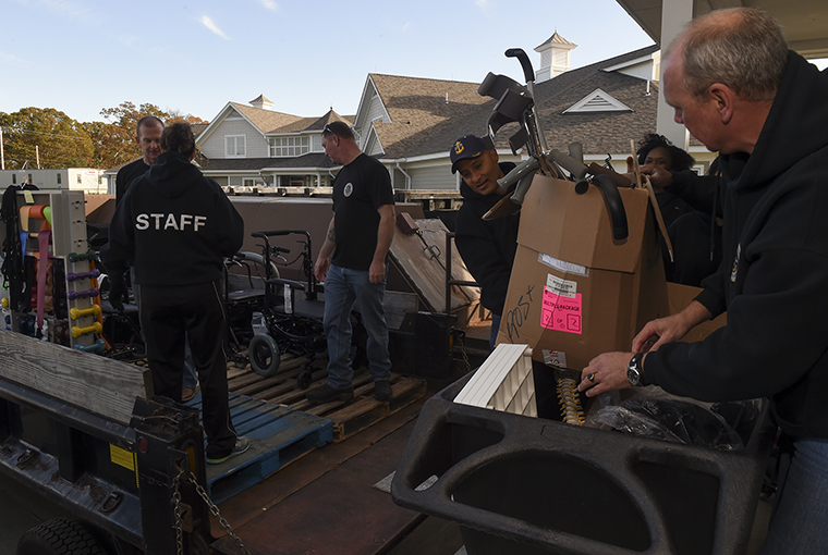 Sailors assigned to U.S. Naval War College’s Senior Enlisted Academy in Newport, Rhode Island unload physical therapy equipment at a newly-built Rhode Island Veterans Home (RIVH).