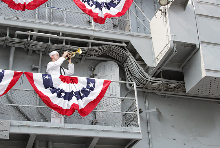 MU2 Edward Reid renders "Taps," honoring the fallen Sailors of USS Intrepid as part of the 75th Anniversary of the Commissioning of the ship.