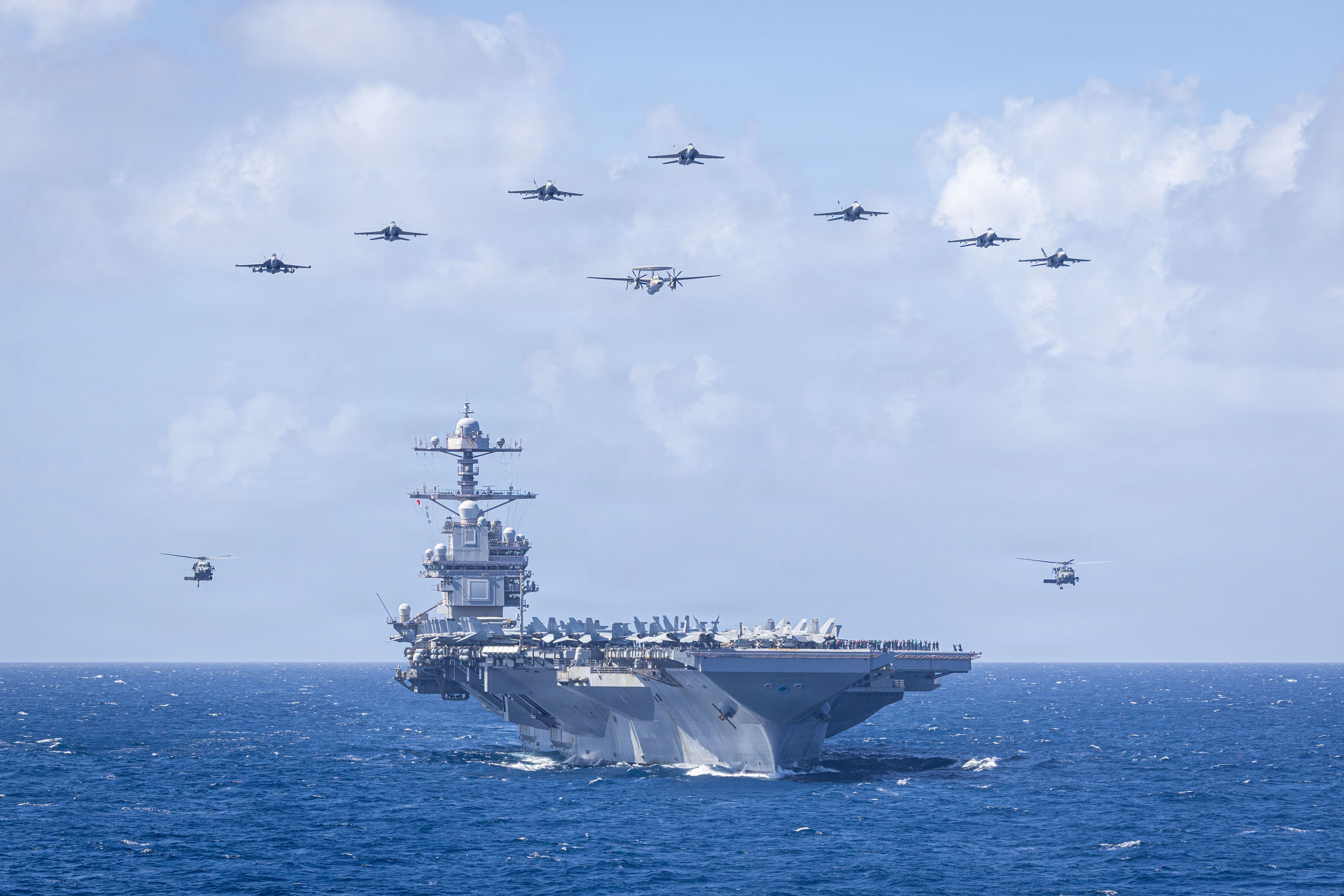 U.S. Navy Carrier Air Wing 8 aircraft fly in formation over the world’s largest aircraft carrier, Ford-class aircraft carrier USS Gerald R. Ford (CVN 78), during Carrier Air Wing 8’s aerial change of command ceremony while underway in the Caribbean Sea, Jan. 19, 2026. U.S. military forces are deployed to the Caribbean in support of the U.S. Southern Command mission, Department of War-directed operations, and the president’s priorities to disrupt illicit drug trafficking and protect the homeland. (U.S. Navy photo)