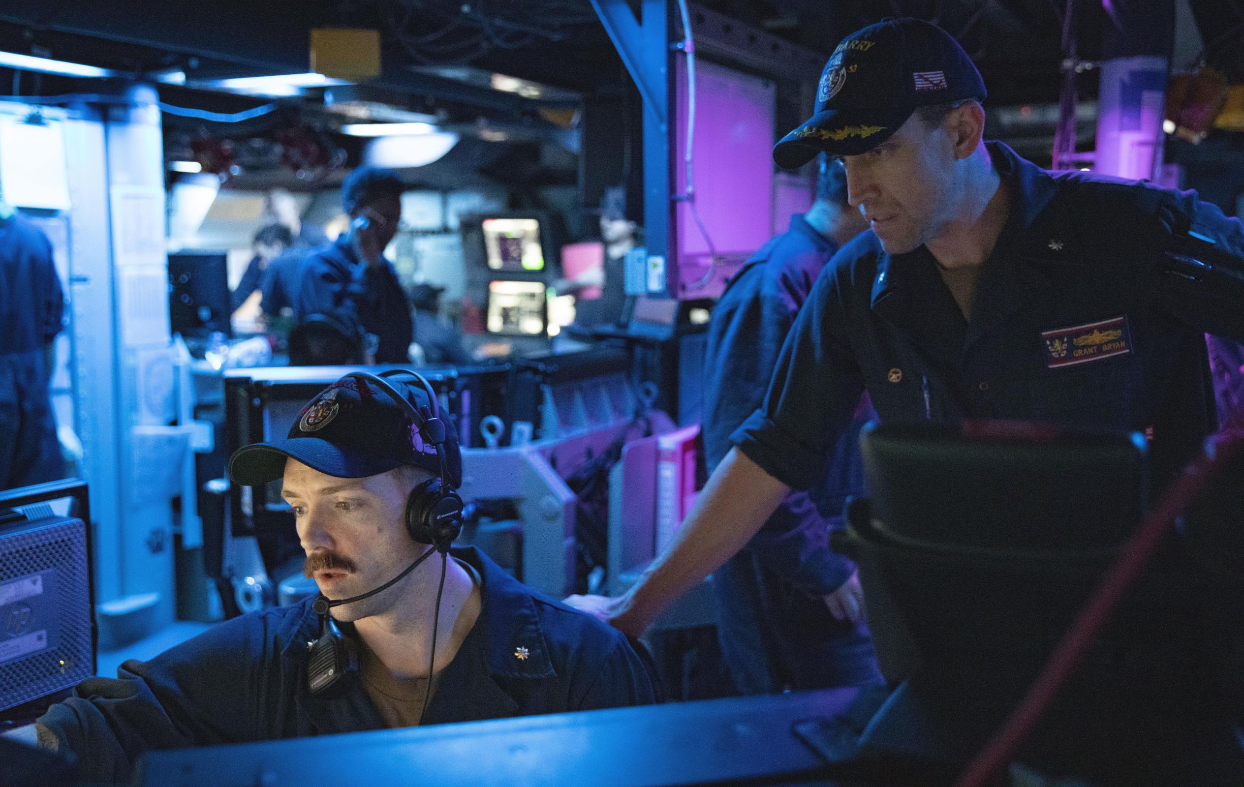 Lt. Cdr. Alex Rose, left, and Cmdr. Grant Bryan, commanding officer of the Arleigh-Burke class guided-missile destroyer USS Barry (DDG 52), prepare for a condition two damage control drill. Barry is assigned to Destroyer Squadron (DESRON) 15 and is underway supporting a free and open Indo-Pacific.