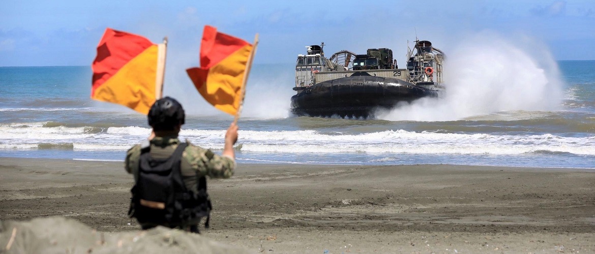 A U.S. Marine from 9th Engineer Support Battalion, 3d Marine Logistics Group guides Landing Craft Air Cushion 29 ashore at Aparri, Philippines during Balikatan 22, March 28, 2022.