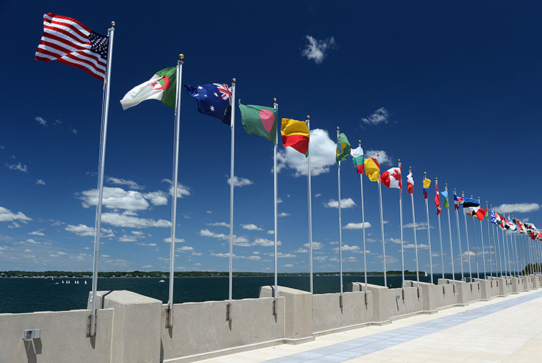 U.S. and international flags representing countries at U.S. Naval War College (NWC) fly during graduation day at NWC in Newport, Rhode Island. One-thousand five-hundred eighteen joint military, civilian, and international students graduated from the NWC, June 20, and were recognized for their achievements during the ceremony. 