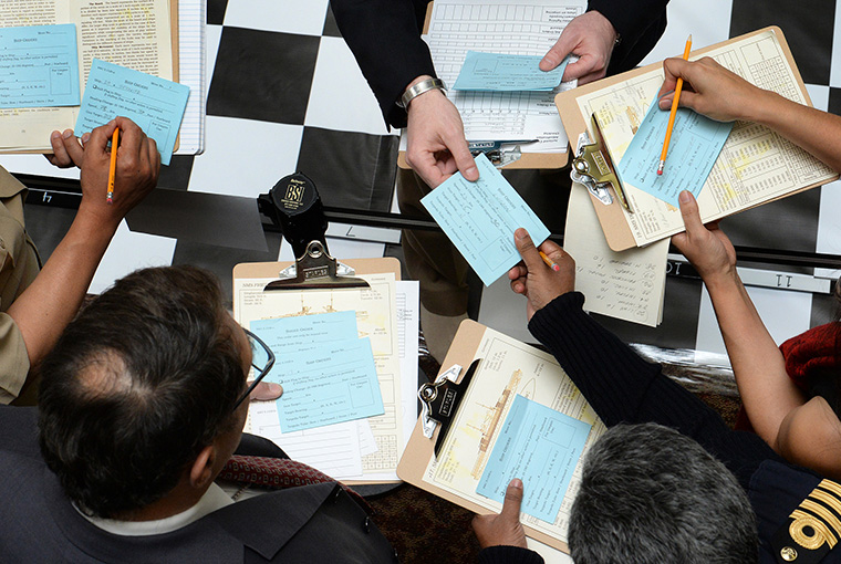 U.S. Naval War College (NWC) staff members collect ships orders during a wargame reenactment of the Battle of Jutland at NWC in Newport, Rhode Island.
