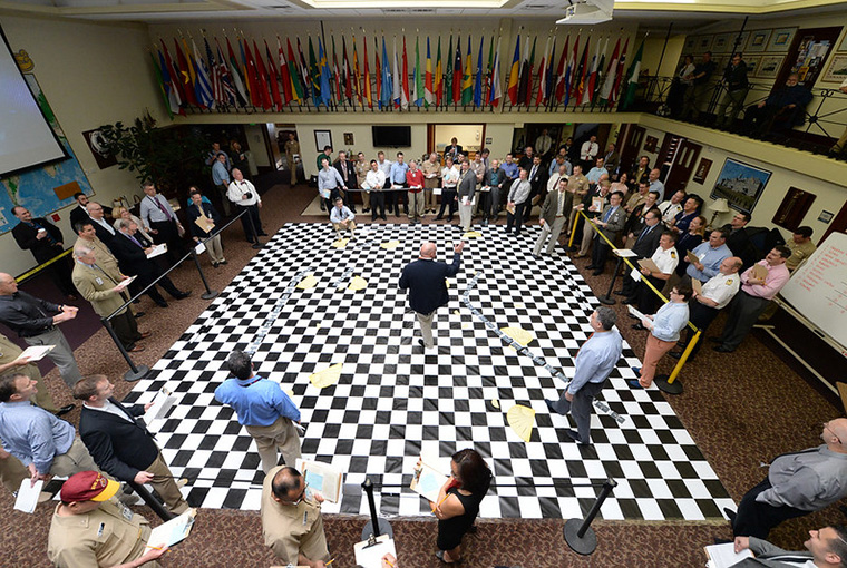 U.S. Naval War College (NWC) staff members listen to a brief during a wargame reenactment of the Battle of Jutland at NWC in Newport, Rhode Island.