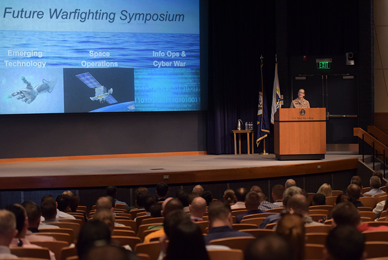 Rear Adm. Shoshana S. Chatfield, president, U.S. Naval War College, welcomes students to the Future Warfighting Symposium held in NWC’s Spruance Auditorium, Aug. 6.