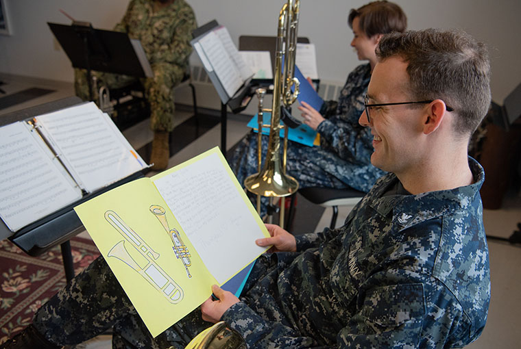 Musician 2nd Class Connor Hailey, assigned to Navy Band Northeast (NBNE), reads a thank you letter sent to the members of NBNE’s Brass Quintet from 5th graders at Agnes Little Elementary School in Pawtucket, Rhode Island.