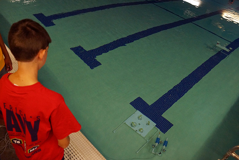 Student standing next to pool at Starship Poseidon STEM Camp.