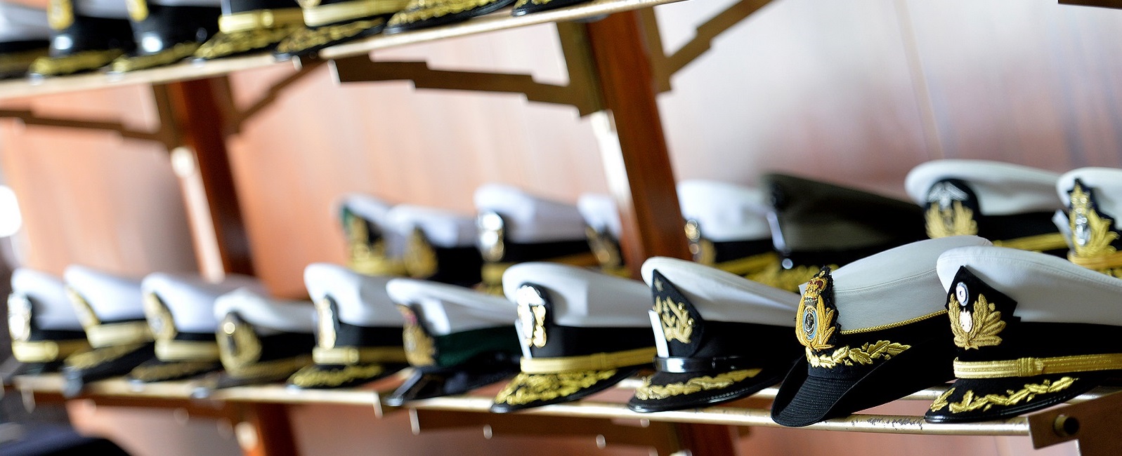 Combination covers representative of several international navies and coast guards sit on display at NWC's 14th Regional Alumni Symposium held at the Peruvian Naval Academy in LaPunta-Callao, Peru. 