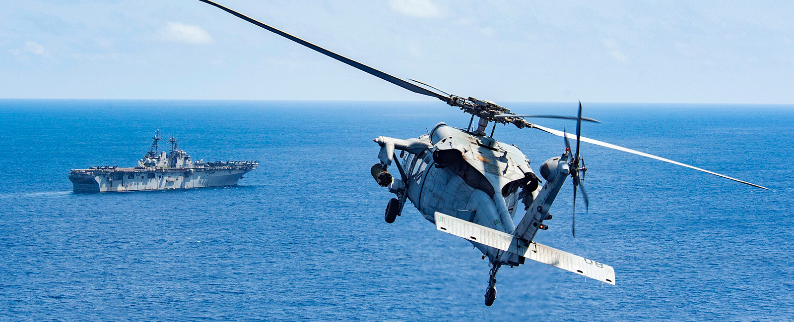 An MH-60S Sea Hawk attached to Helicopter Sea Combat Squadron 25 (HSC-25) approaches the amphibious assault ship USS Wasp (LHD 1).