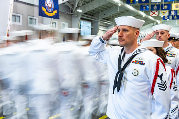 Recruit division commanders salute graduating divisions as they enter Midway Ceremonial Drill Hall during a pass in review graduation ceremony at Recruit Training Command.