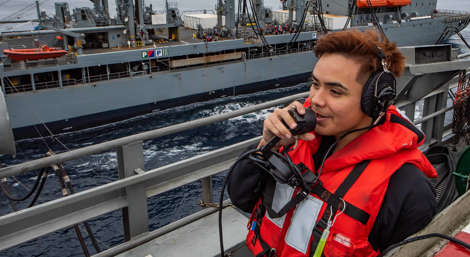 Seaman Shelbyan Diaz, from Harlingen, Texas, uses a sound-powered telephone to report the distance between the aircraft carrier USS Theodore Roosevelt (CVN 71) and the Military Sealift Command fleet replenishment oiler USNS Yukon (T-AO 202), Dec. 3, 2019.